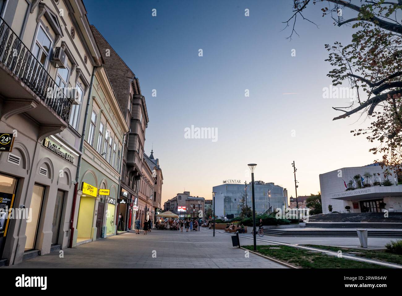 Foto di persone che passano per l'area pedonale di piazza Pozorisni trg a Novi Sad, Serbia, durante un pomeriggio di sole al tramonto. Novi Sad è la seconda la Foto Stock