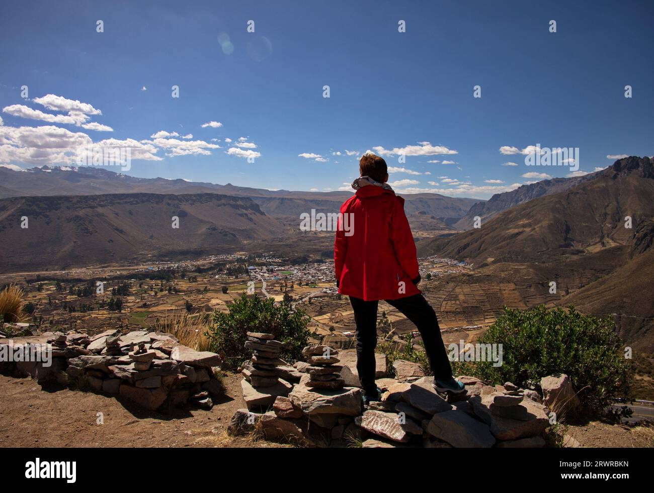 Vista posteriore di una donna anziana in piedi sopra la valle di Chivay, in Perù Foto Stock