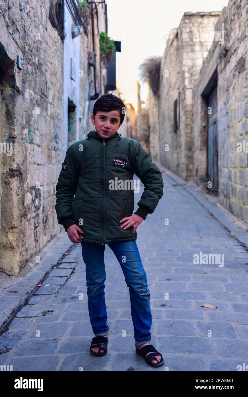 Un ragazzo del posto fuori da un grande negozio che vendeva sapone di Aleppo. Sembrava bello, tranne che in inverno non dovrebbe indossare infradito. Aleppo, Siria Foto Stock