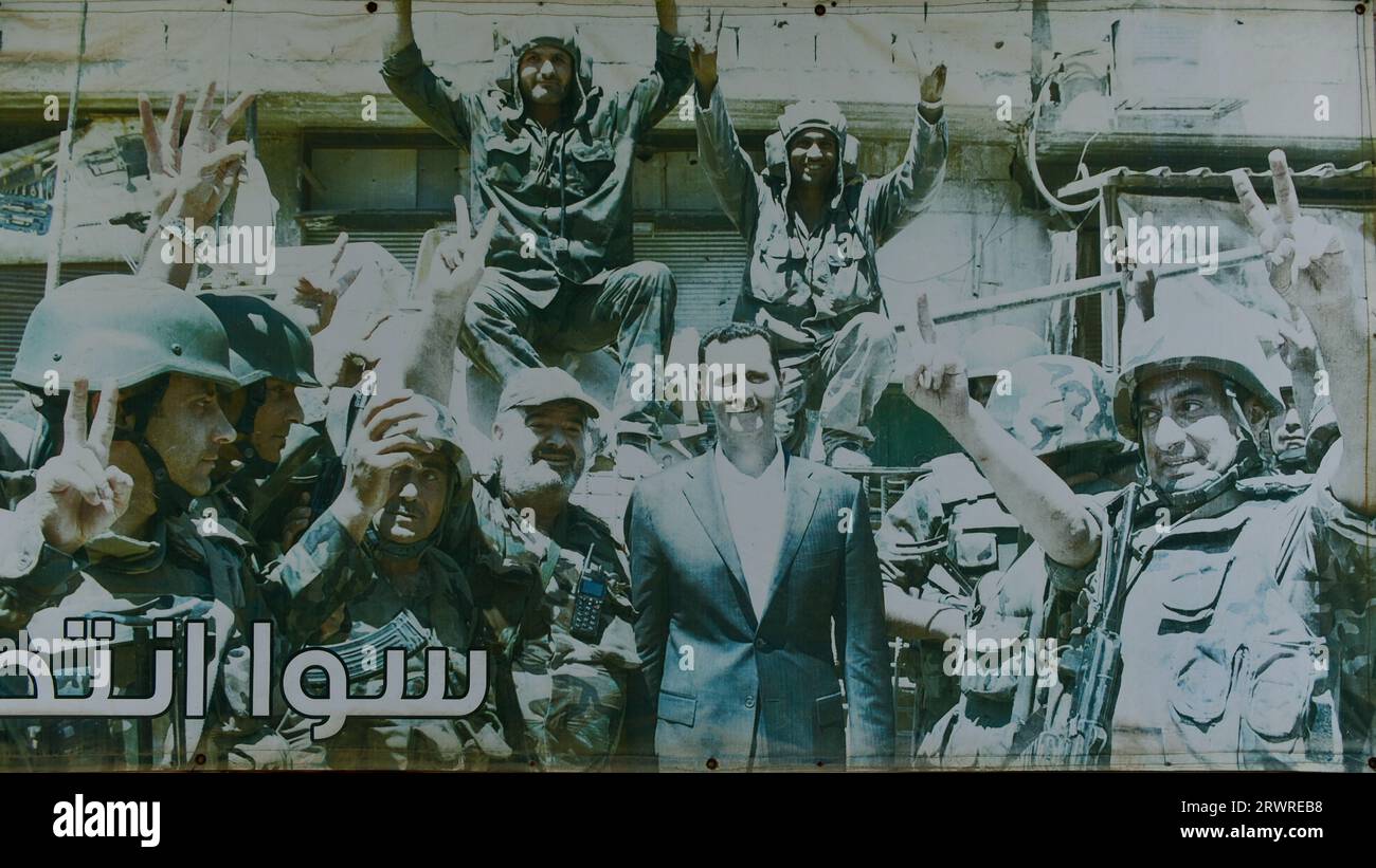 Un poster che mostra Bashar al-Assad al posto di frontiera ad alta tensione a Quneitra, sul lato siriano delle alture del Golan. Un pezzo di propaganda siriana Foto Stock