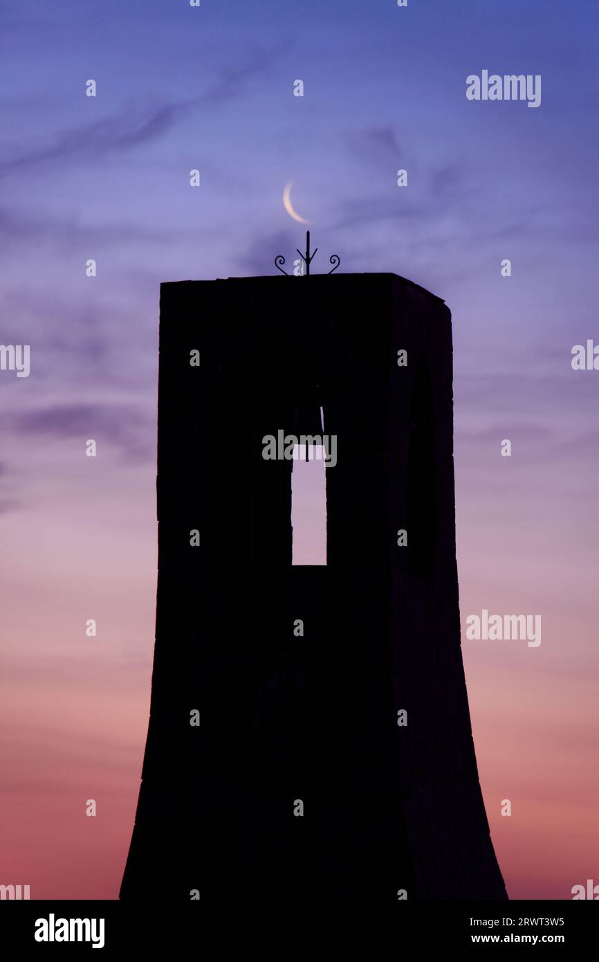 Primo piano della torre e della luna all'alba Foto Stock