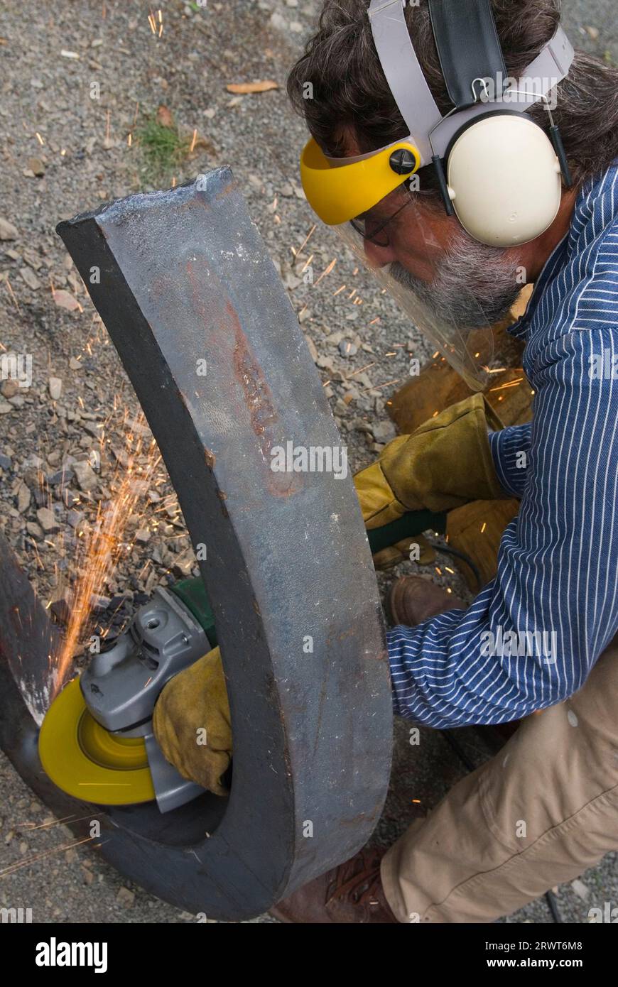 Uomo che strofina un pezzo di metallo per mezzo di un disco abrasivo e di un flex. Uomo che strofina un pezzo di metallo per mezzo di un Flex Foto Stock