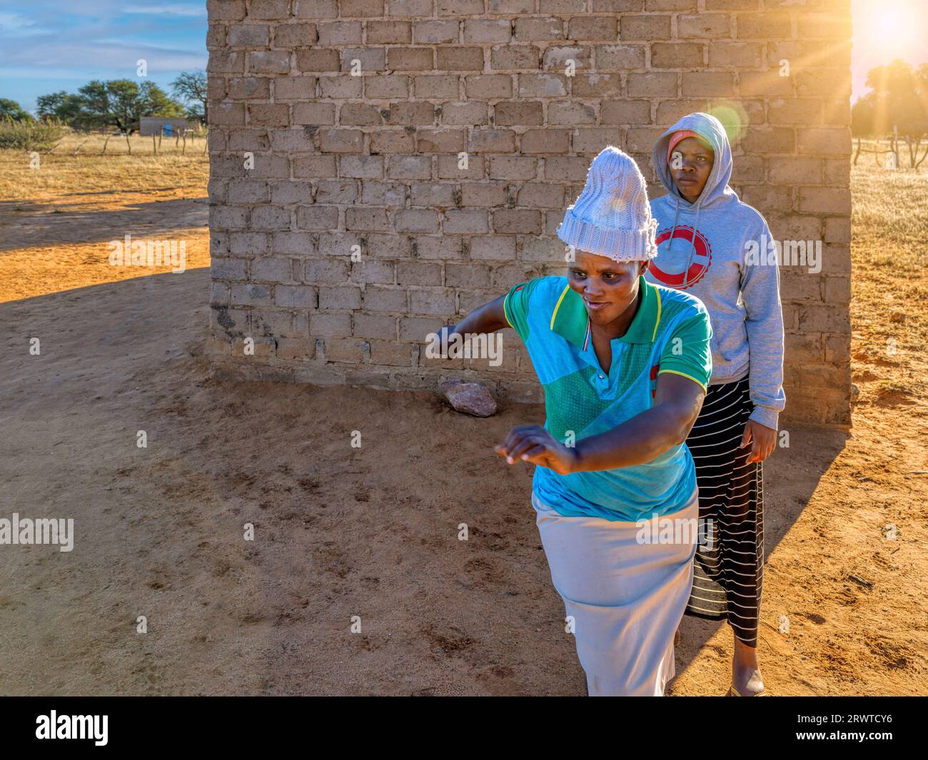 villager donna africana adulta che corre spaventata e veloce come se dimenticasse qualcosa, senso di urgenza, villaggio in Botswana, Foto Stock