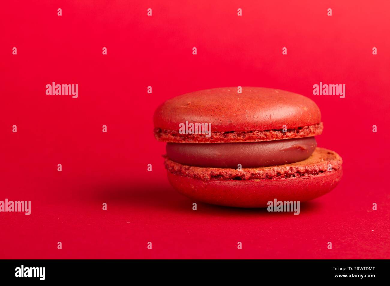 Primo scatto macro di un macaron, spuntino francese, su uno sfondo colorato. Foto Stock