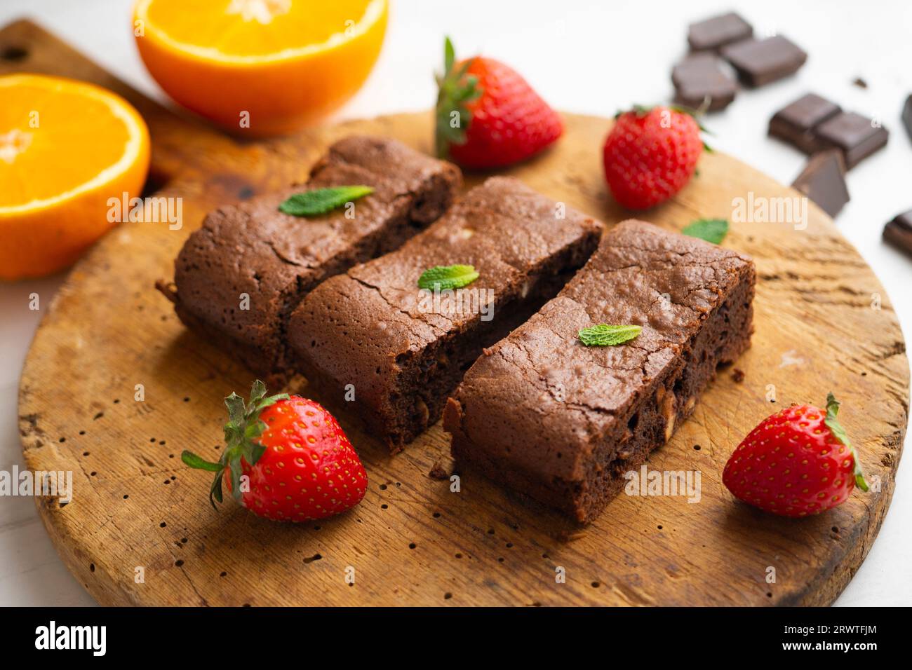 Brownie al cioccolato tagliato a porzioni e decorato con fragole e menta. Foto Stock