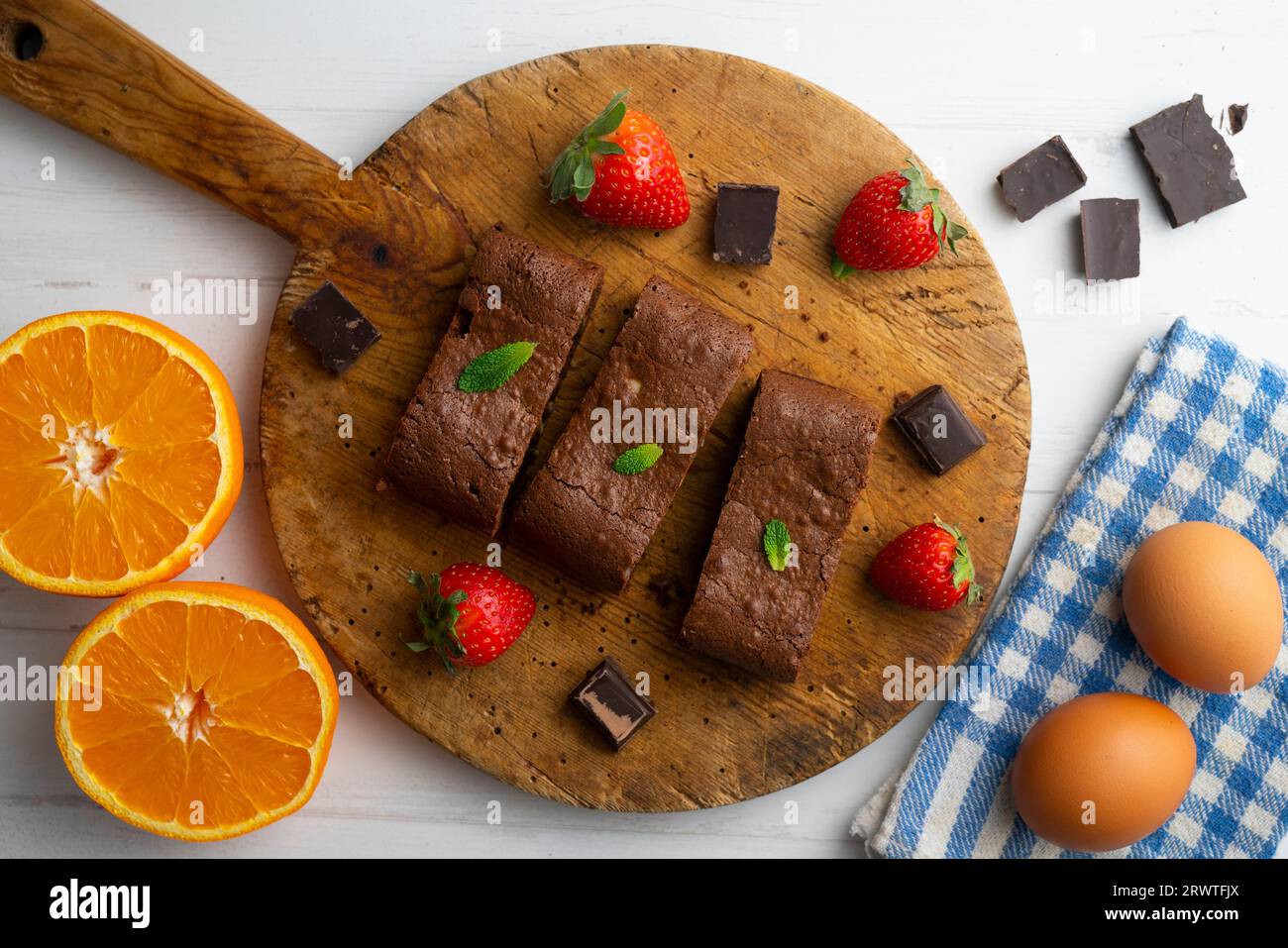 Brownie al cioccolato tagliato a porzioni e decorato con fragole e menta. Foto Stock