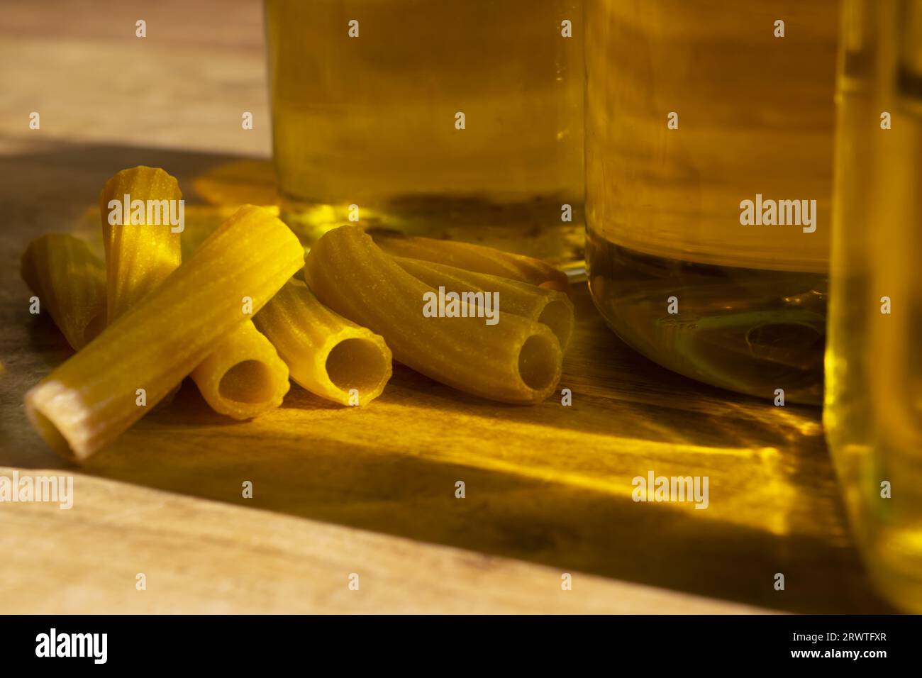 pasta vista attraverso i riflessi delle bottiglie d'olio Foto Stock