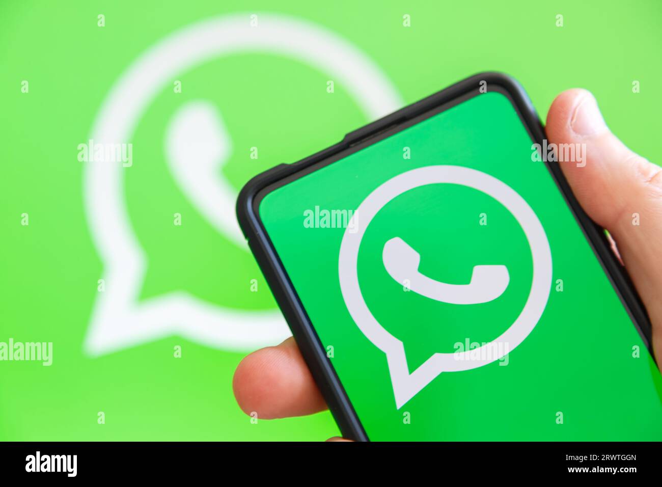 Stoccarda, Germania - 20 luglio 2023: Mano che regge un telefono cellulare con il logo WhatsApp, app Messenger, schermo del computer a Stoccarda, Germania. Foto Stock