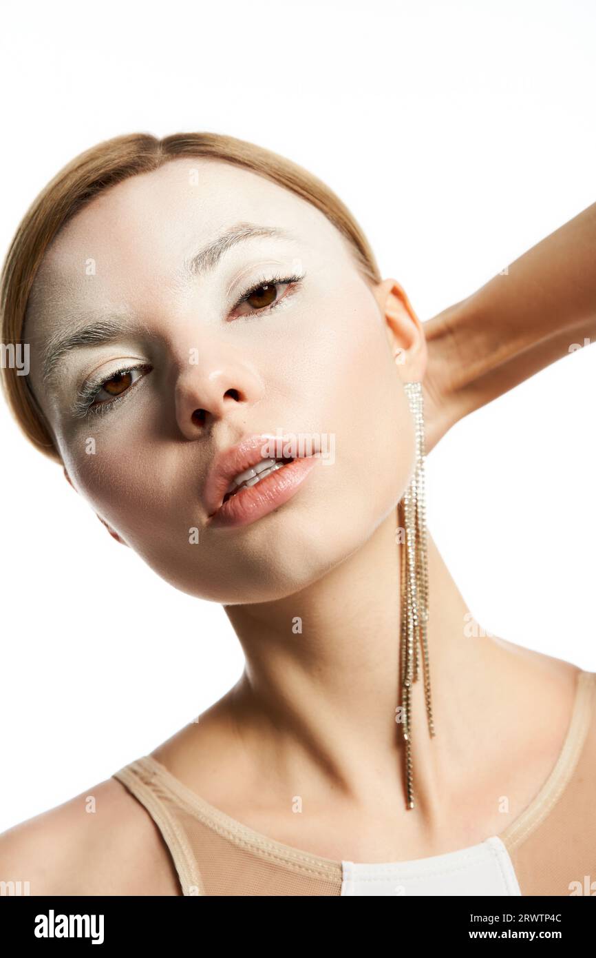 ritratto di donna con volto angelico e trucco etereo che guarda la fotocamera su una bellezza bianca e celeste Foto Stock