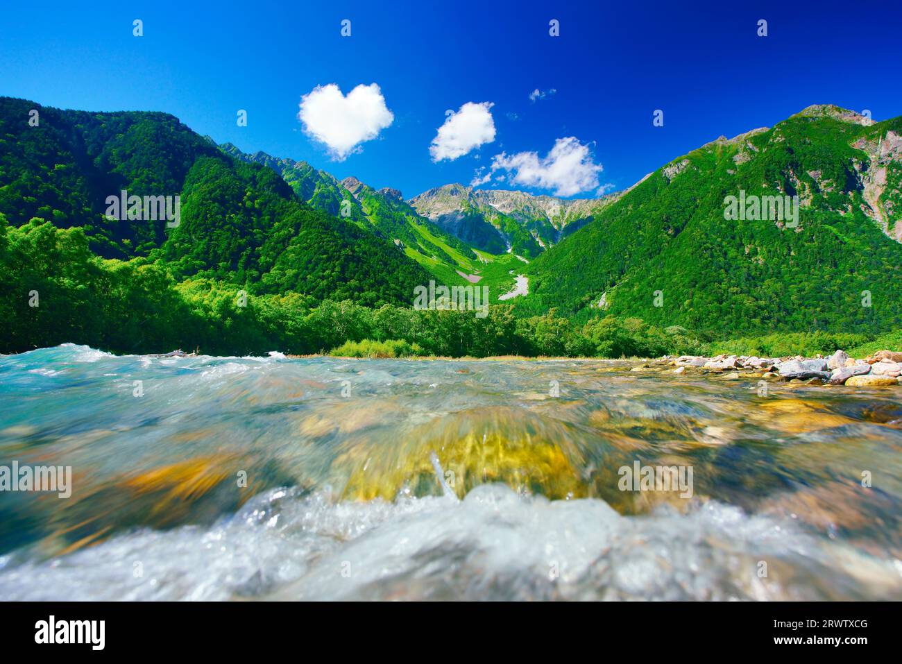 Il limpido torrente del fiume Azusa, la catena montuosa Hotaka e le nuvole a forma di cuore Foto Stock