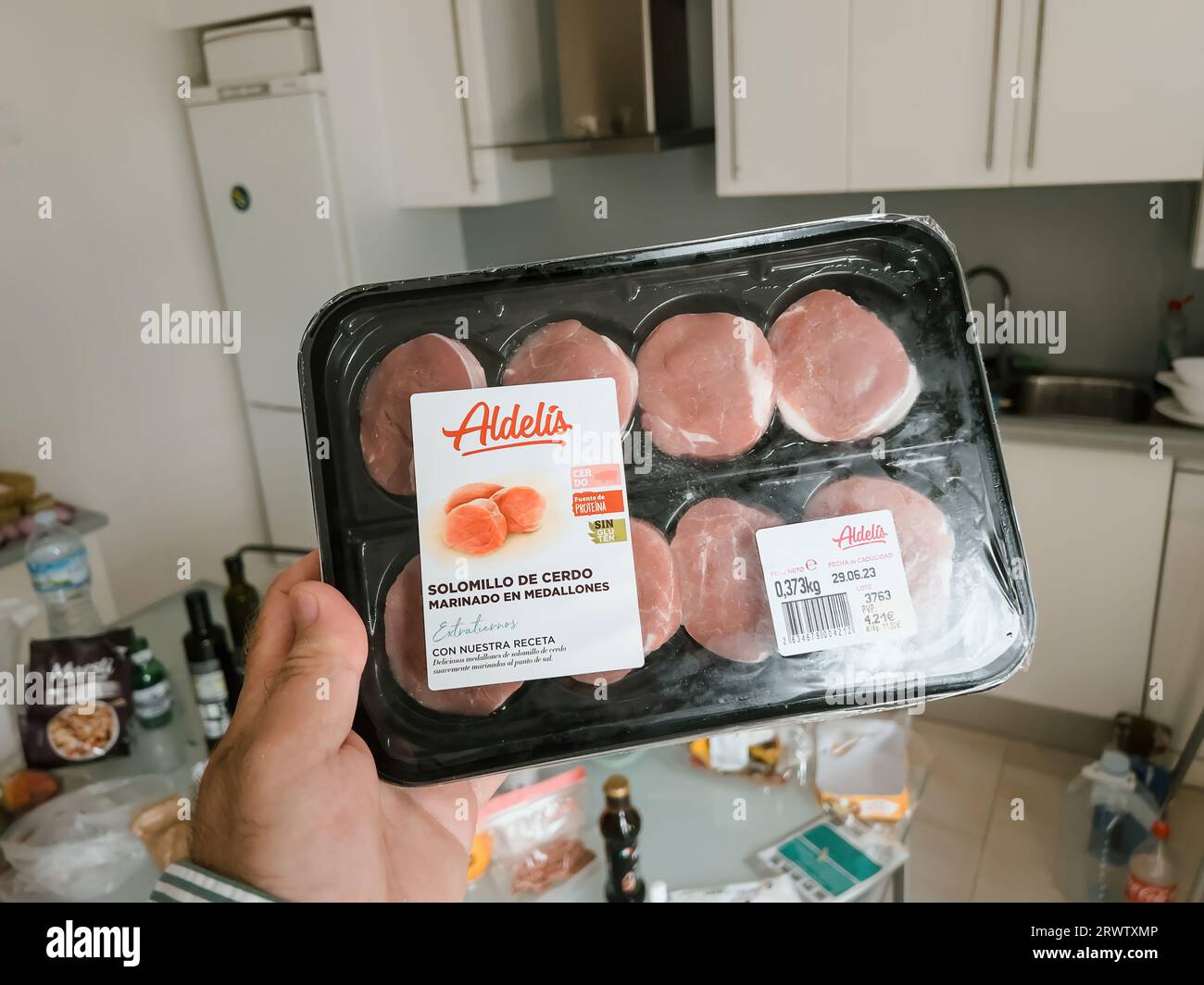 Maiorca, Spagna - 30 giugno 2023: Da un punto di vista, una mano regge Solomillo de Cerdo Marinado en Medallones, marchio Aldelis, al prezzo di 4,21 euro, evocando una deliziosa esperienza culinaria spagnola Foto Stock