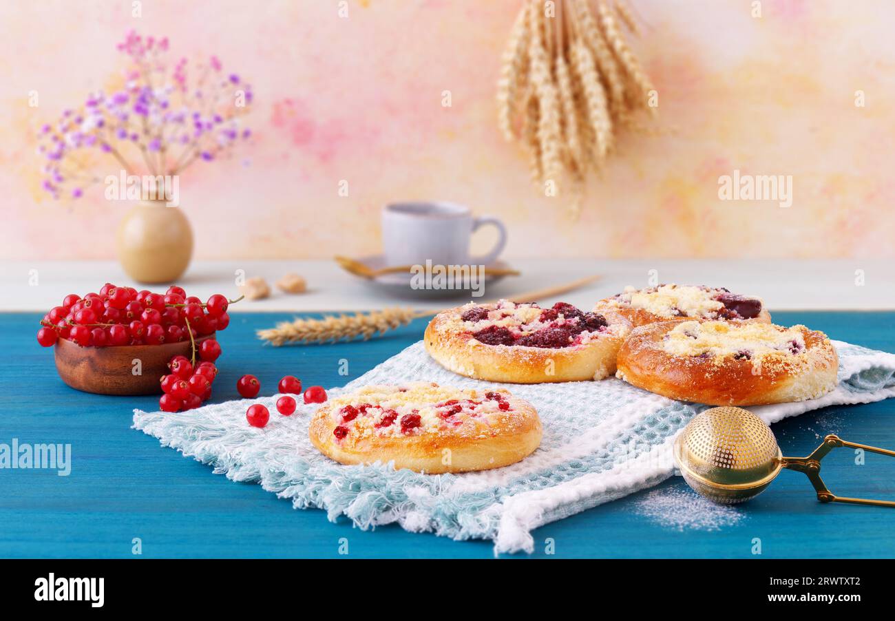 Torte di frutta al forno con pasticcerie estive fresche, ribes, ciliegie, more, mirtilli e crumble su tavola di legno blu, angolo di vista basso, selectiv Foto Stock