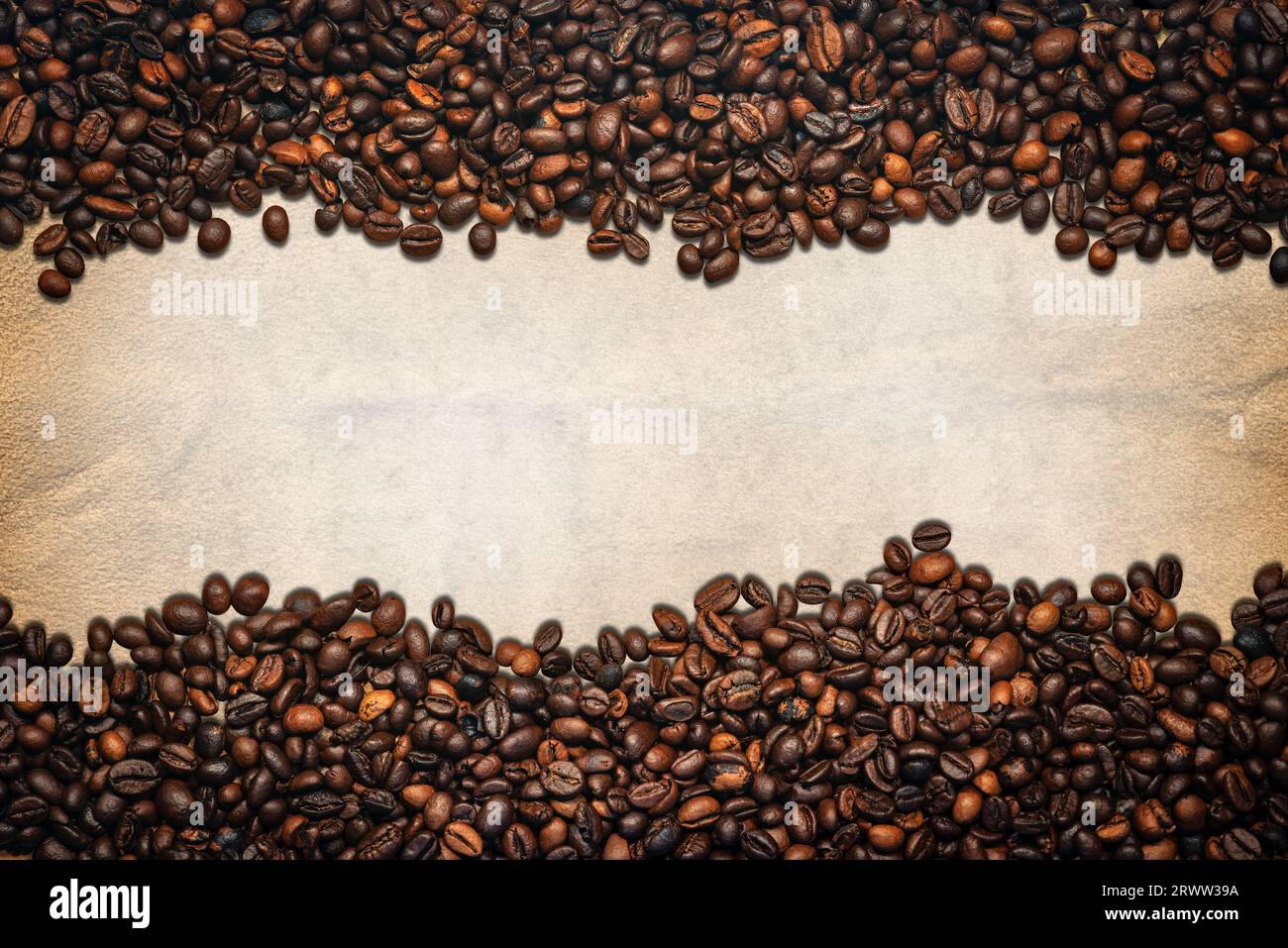 Grande gruppo di chicchi di caffè tostati su una pergamena vuota con spazio per le copie. Composizione orizzontale, modello, fotografia. Foto Stock