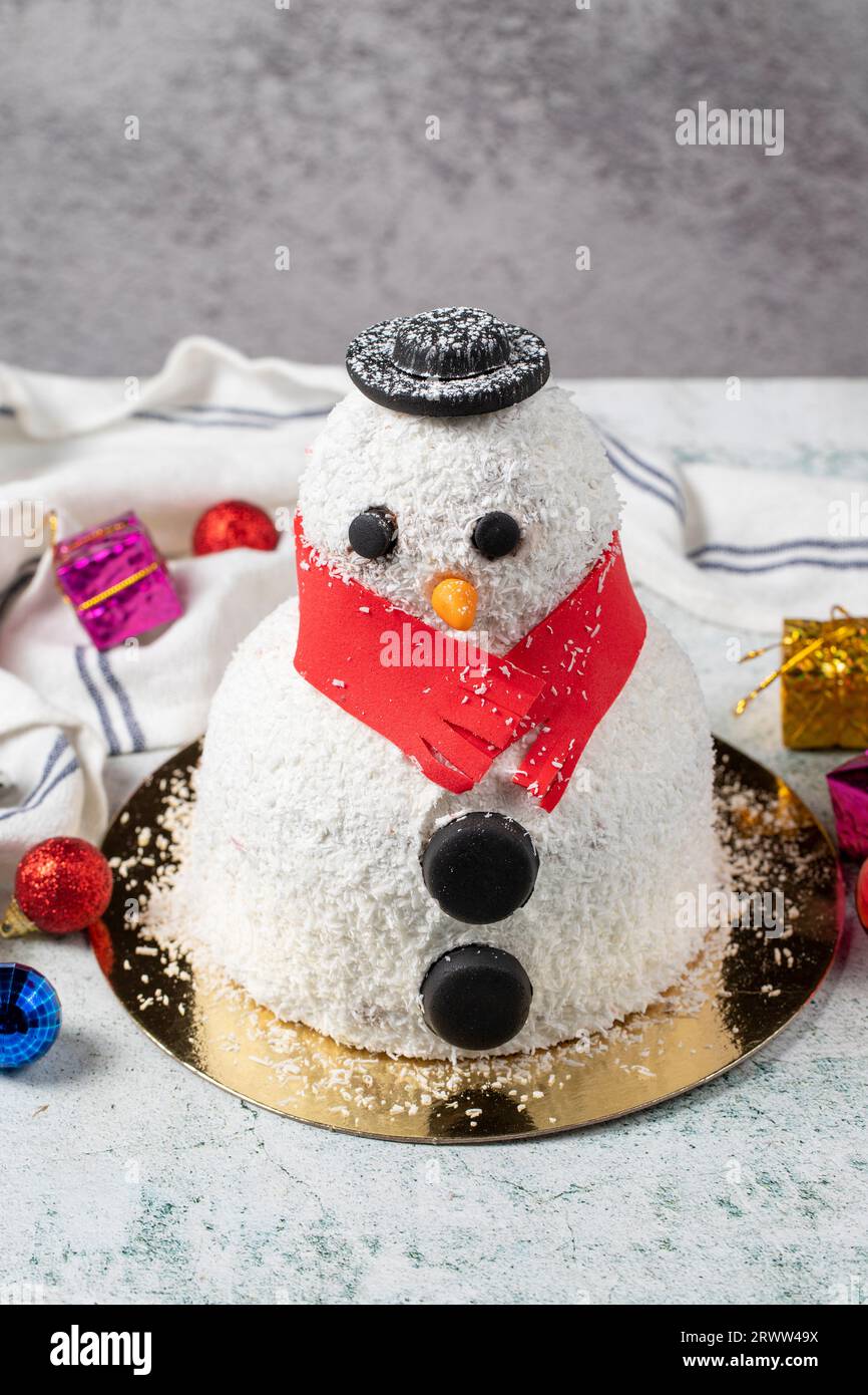 Torta di natale Snowman. Il concetto di Capodanno. Torta a forma di pupazzo di neve preparata per la celebrazione di Capodanno su sfondo grigio Foto Stock