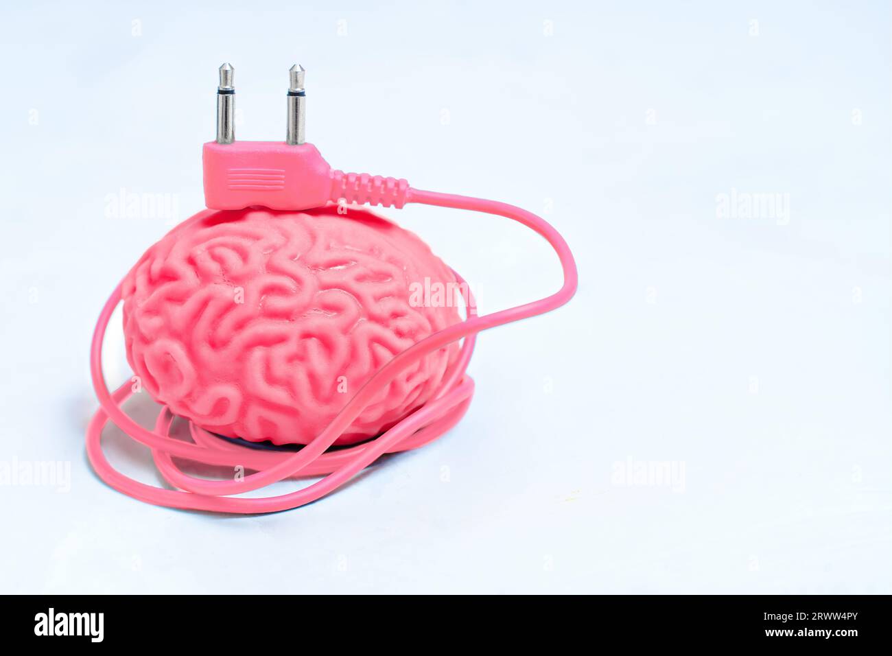 Modello di cervello umano con cavo di alimentazione corrispondente collegato. Concetto correlato a Mind Boost. Foto Stock