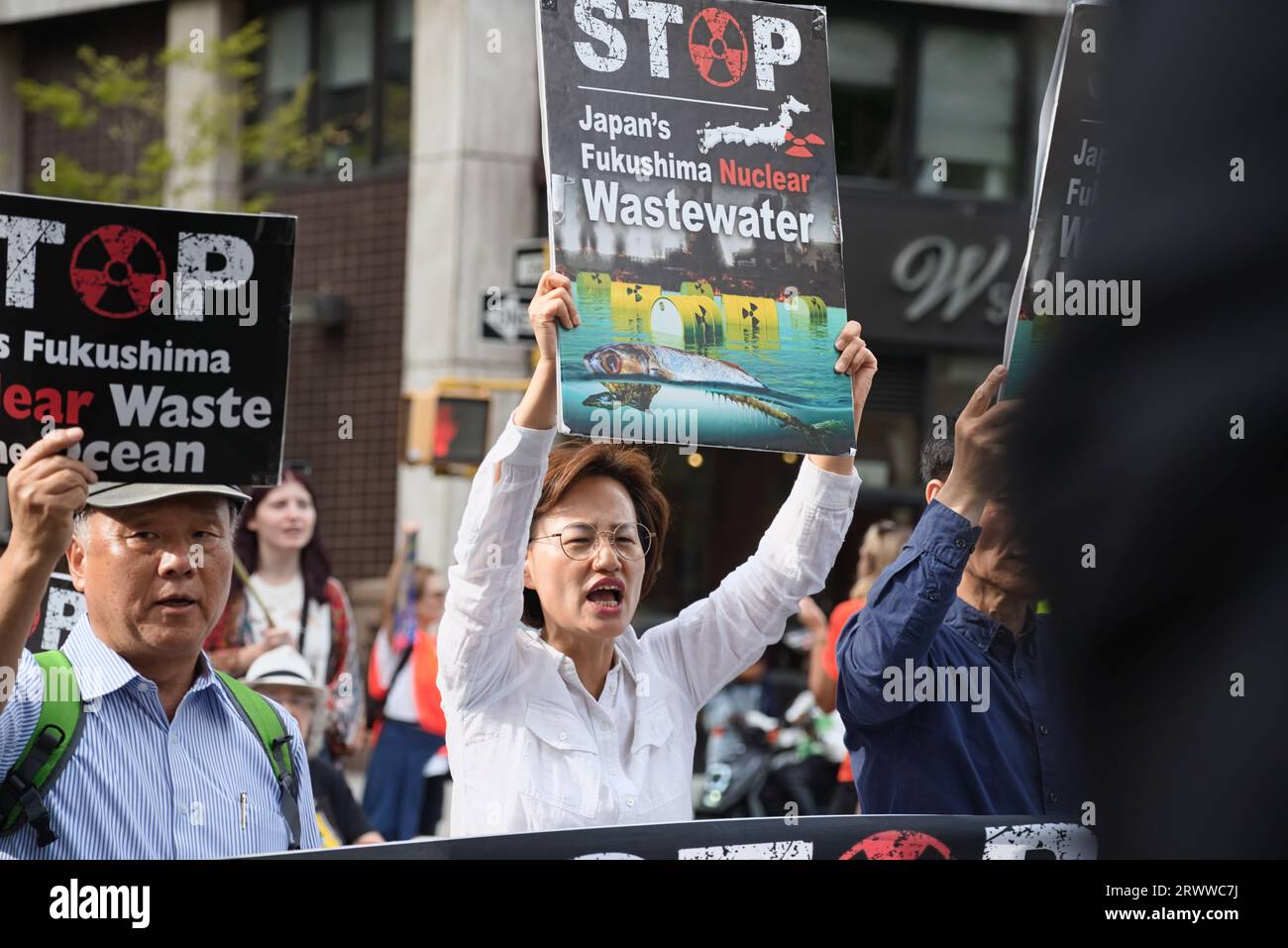 New York, NY - 17 settembre 2023: I manifestanti asiatici arrabbiati marciano mentre tengono in mano i segnali per fermare il rilascio di acque reflue radioattive di Fukushima nell'oceano Foto Stock