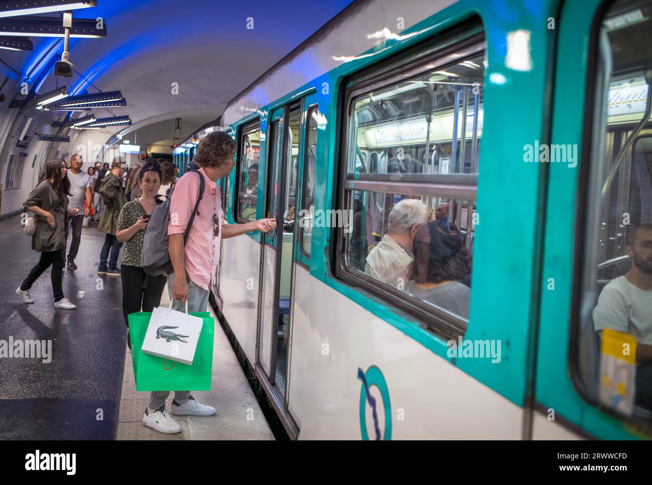 I passeggeri salgono a bordo di un treno della metropolitana di Parigi alla stazione Gambetta sulla linea 4 a Parigi, Francia. Foto Stock