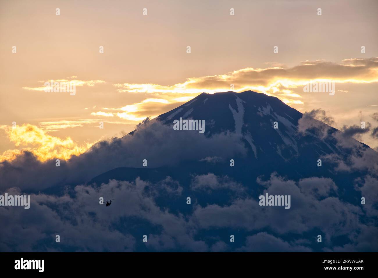 Fuji al tramonto con nuvole e un elicottero da combattimento Foto Stock