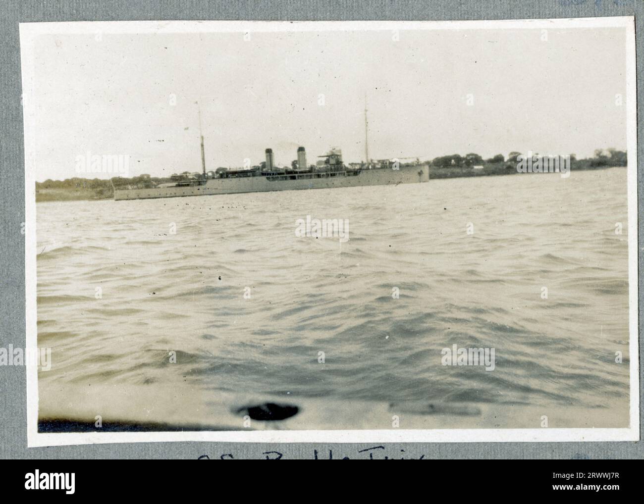 Vista di un edificio ufficiale, in parte nascosto dietro gli alberi e di un'alta parete, vista da fondo strada. C'è anche un cannone sulla sinistra, proprio dietro un muro basso in primo piano. Didascalia del testo originale: High Courts, Mombasa. Foto Stock