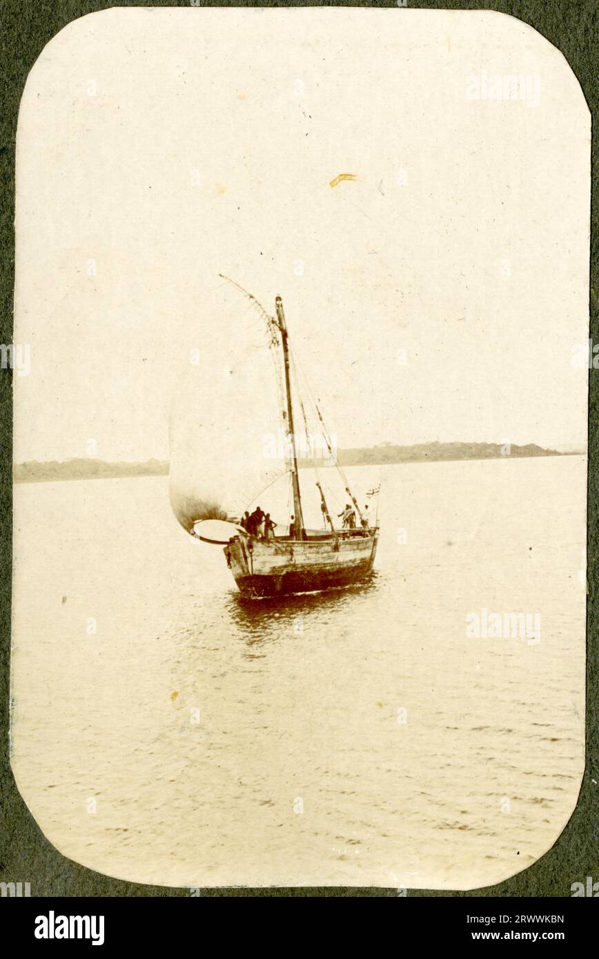 Veduta di un dhow con il suo equipaggio africano nel mezzo di un lago, forse il Lago Victoria. Didascalia del testo originale: Dhow on Lake. Foto Stock