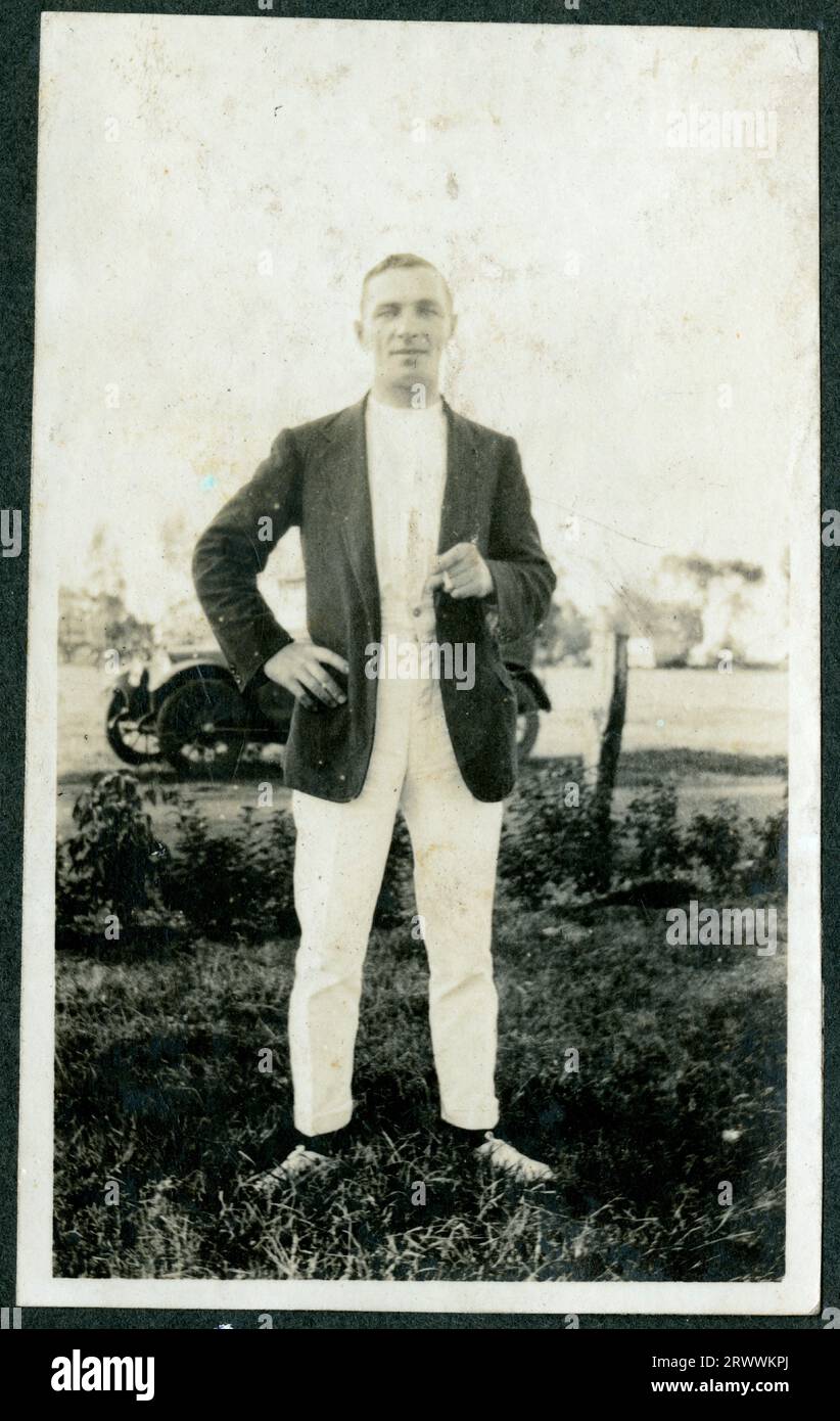Ritratto di un uomo europeo identificato come C.S.M. Jones, fumando casualmente fuori con un'auto visibile attraverso l'erba dietro di lui. Didascalia del testo originale: C.S.M. [sergente maggiore della compagnia] Jones. Foto Stock