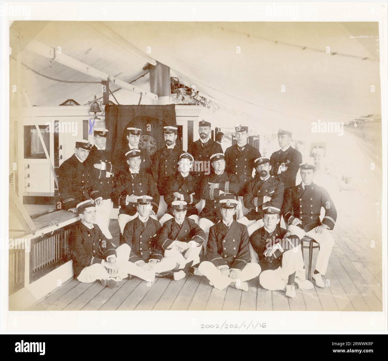 Ritratto di gruppo di diciassette ingegneri maschi della Royal Indian Marine in uniforme completa. Sono sul ponte di una nave e seduti o in piedi in tre file. La persona contrassegnata con una croce è George Wood. La didascalia scritta a mano recita: X G e Wood. Gruppo di ingegneri della Royal Indian Marine. Foto Stock