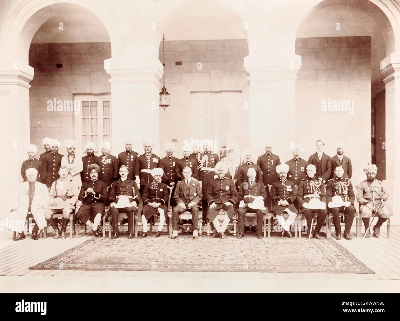Dignitari indiani e britannici in uniforme si schierano per un ritratto di gruppo sotto gli archi a pilastri del Palazzo Kapurthala nel Punjab. DIDASCALIA DEL MANOSCRITTO ORIGINALE: NORMAN S.S.S.O FRENCH TIKKA SAHIB H.H. KAPURTHALA BORLTON ABDUL HAMID E.C.B H.E.W. FEROZ KHAN KAPURTHALA 13/14/2/20. Foto Stock
