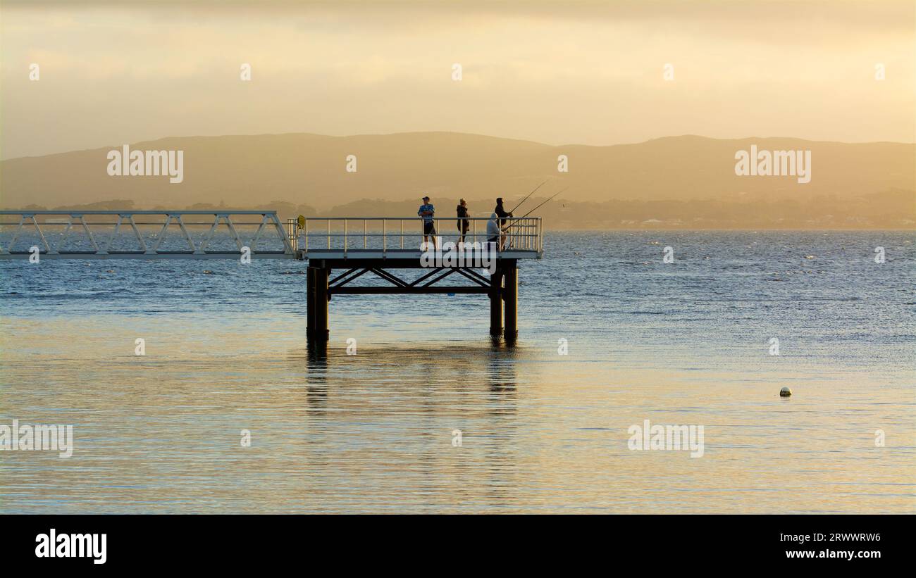 Persone su un molo per pescare vicino al tramonto al Princess Royal Harbour, Albany, Australia Occidentale Foto Stock