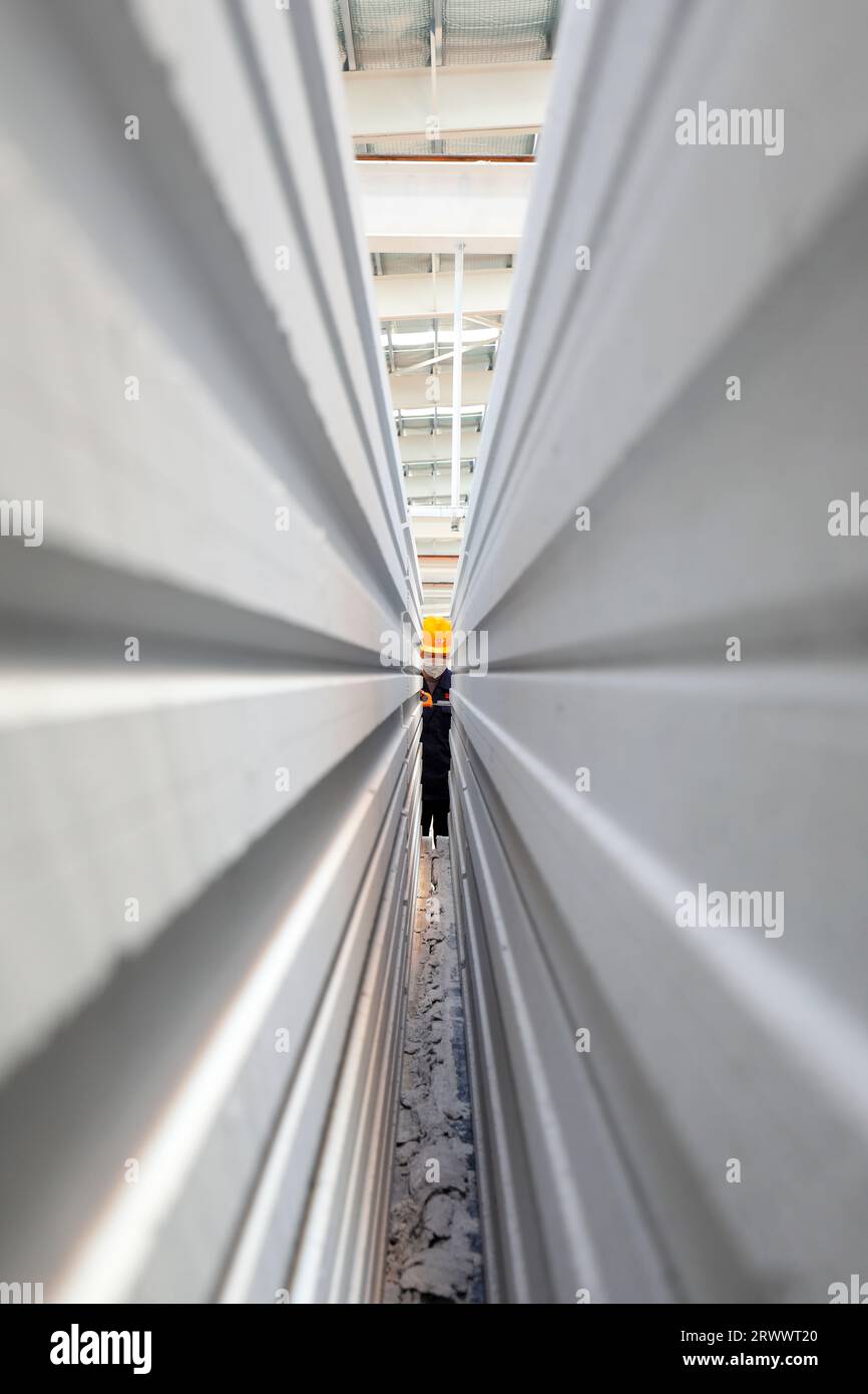 Contea di Luannan, Cina - 17 giugno 2023: I lavoratori stanno lavorando intensamente sulla linea di produzione di nuovi materiali da costruzione - pannelli divisori leggeri Foto Stock