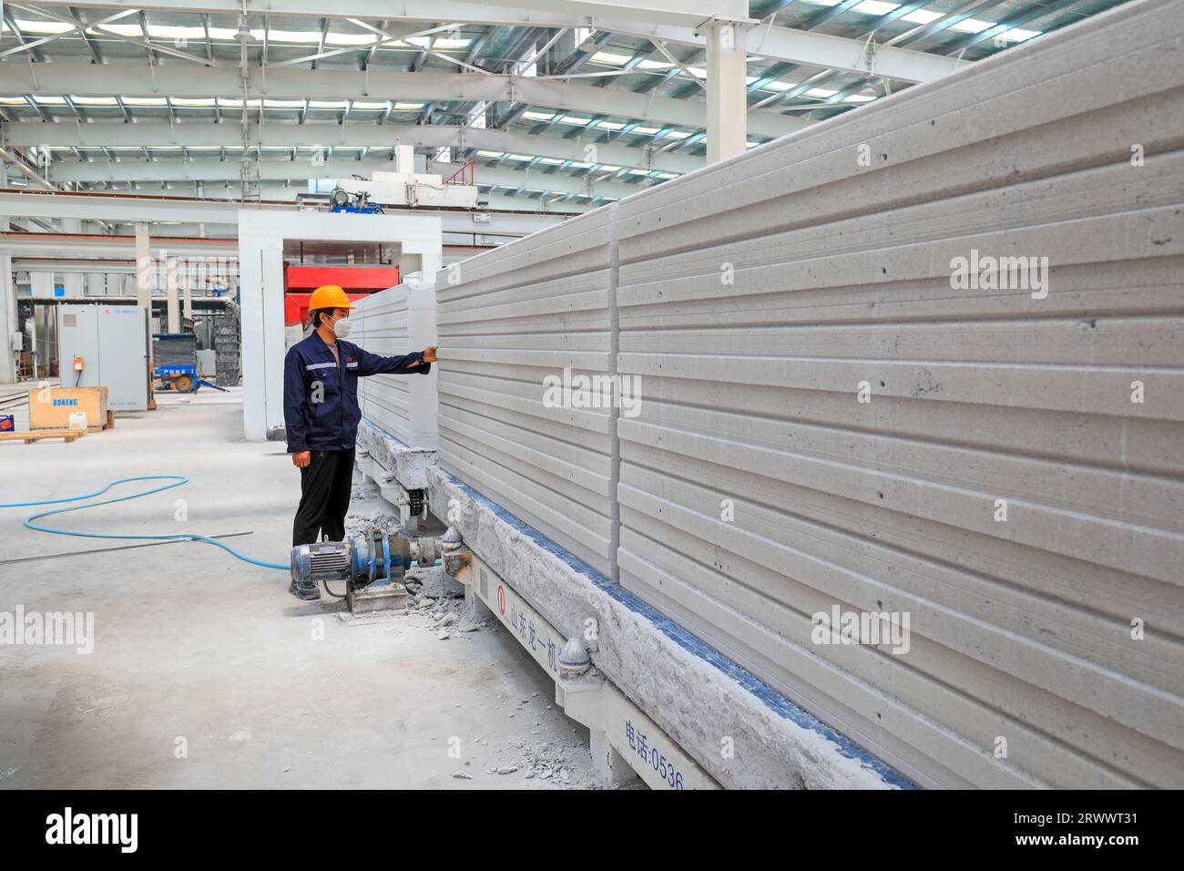 Contea di Luannan, Cina - 17 giugno 2023: I lavoratori stanno lavorando intensamente sulla linea di produzione di nuovi materiali da costruzione - pannelli divisori leggeri Foto Stock