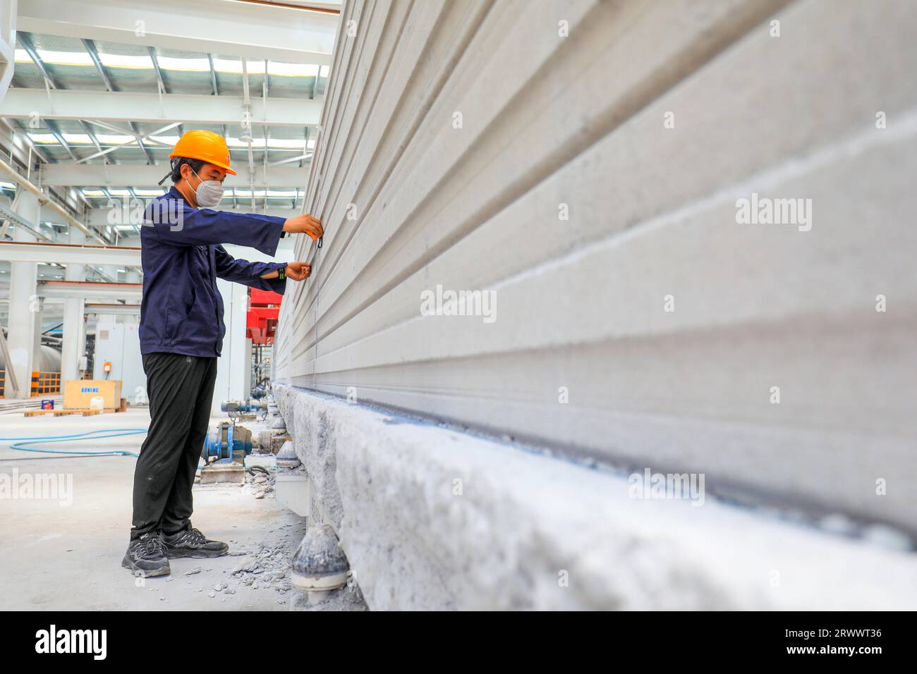 Contea di Luannan, Cina - 17 giugno 2023: I lavoratori stanno lavorando intensamente sulla linea di produzione di nuovi materiali da costruzione - pannelli divisori leggeri Foto Stock