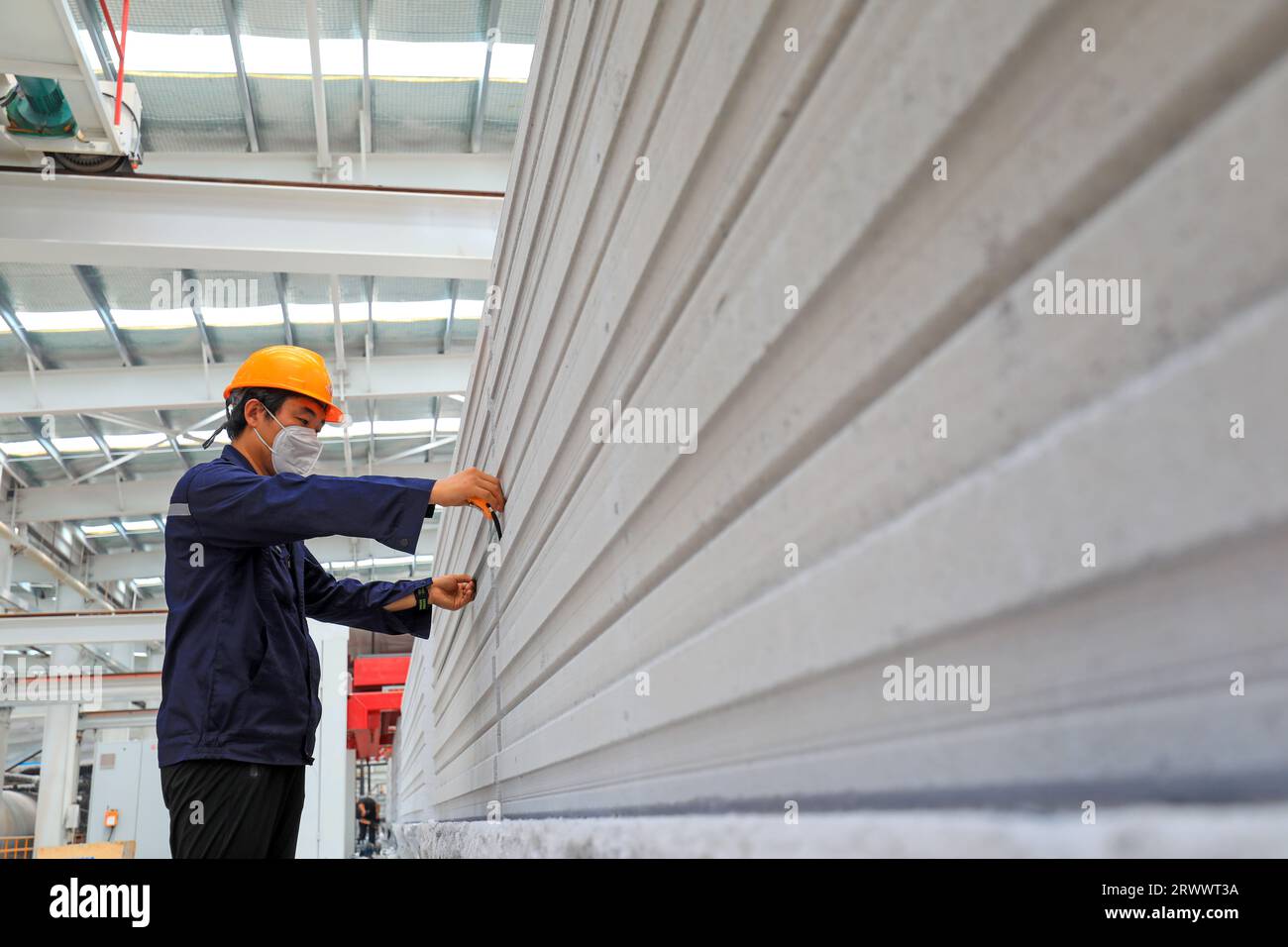 Contea di Luannan, Cina - 17 giugno 2023: I lavoratori stanno lavorando intensamente sulla linea di produzione di nuovi materiali da costruzione - pannelli divisori leggeri Foto Stock