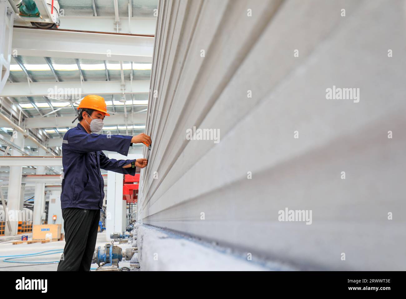 Contea di Luannan, Cina - 17 giugno 2023: I lavoratori stanno lavorando intensamente sulla linea di produzione di nuovi materiali da costruzione - pannelli divisori leggeri Foto Stock