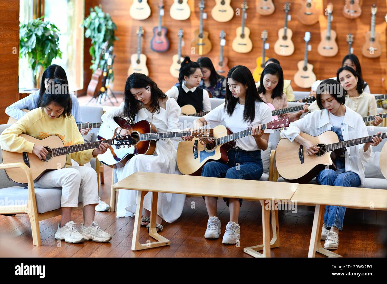 (230921) -- GUIYANG, 21 settembre 2023 (Xinhua) -- la gente impara a suonare la chitarra in uno showroom di Natasha Musical Instrument Manufacturing Co., Ltd. Nella contea di Zheng'an, nella provincia di Guizhou della Cina sud-occidentale, 13 maggio 2022. Dopo più di 200 elaborate e lunghe procedure di produzione, le chitarre squisitamente lavorate escono come prodotti caratteristici della contea di Zheng'an nella provincia di Guizhou, nella Cina sud-occidentale. Queste opere d'arte vengono poi distribuite al mondo attraverso i treni merci Cina-Europa, il trasporto per vie d'acqua e altri mezzi. PER ANDARE CON "Economic Watch: L'industria della produzione di chitarre cinesi cavalca su W Foto Stock