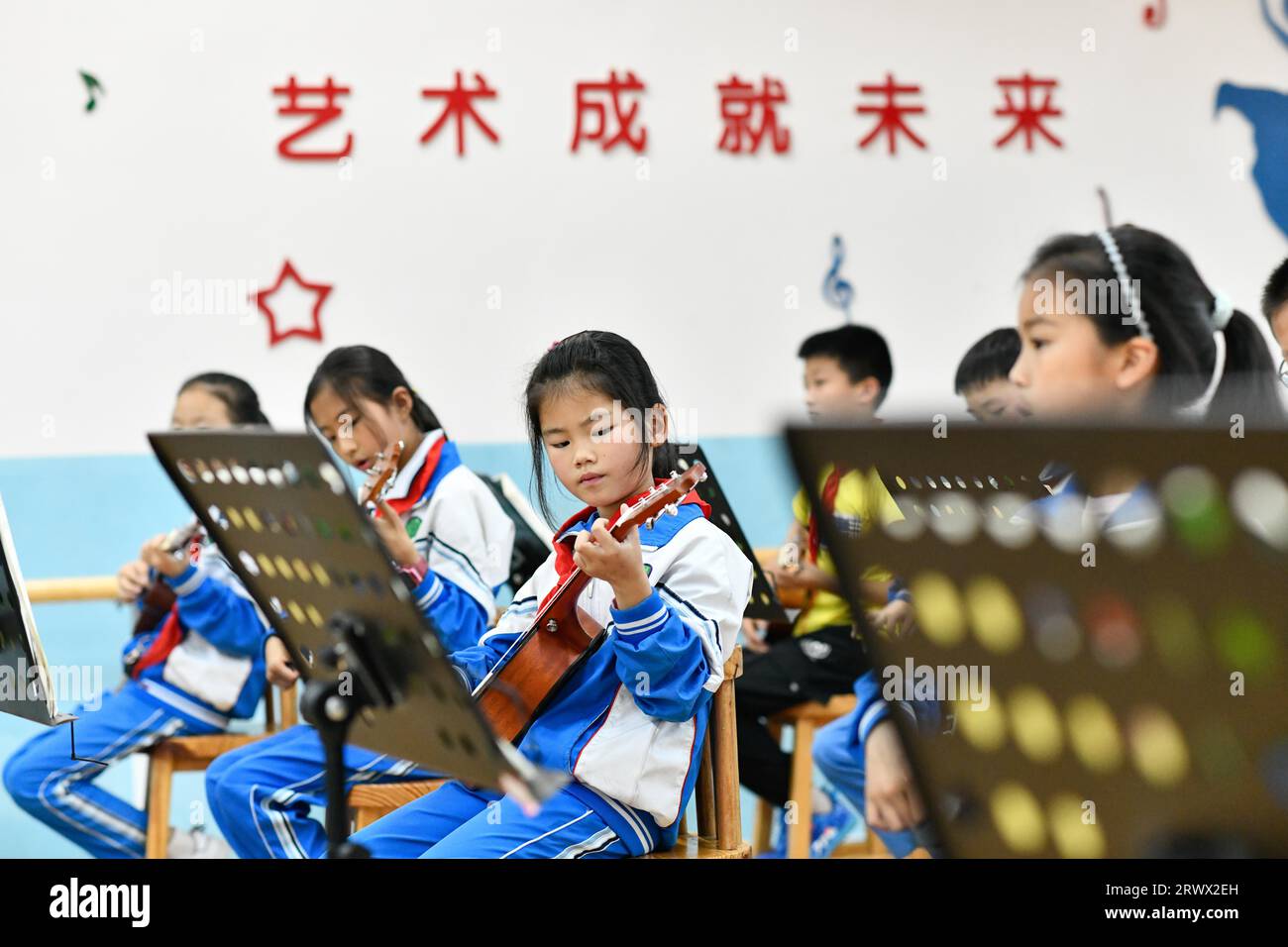(230921) -- GUIYANG, 21 settembre 2023 (Xinhua) -- gli studenti imparano a giocare all'ukulele in una scuola elementare nella contea di Zheng'an, nella provincia di Guizhou della Cina sud-occidentale, 13 maggio 2022. Dopo più di 200 elaborate e lunghe procedure di produzione, le chitarre squisitamente lavorate escono come prodotti caratteristici della contea di Zheng'an nella provincia di Guizhou, nella Cina sud-occidentale. Queste opere d'arte vengono poi distribuite al mondo attraverso i treni merci Cina-Europa, il trasporto per vie d'acqua e altri mezzi. PER ANDARE CON "Economic Watch: L'industria cinese della produzione di chitarre cavalca WAVE of Belt and Road Initiative" (Xinhua/Yang Foto Stock