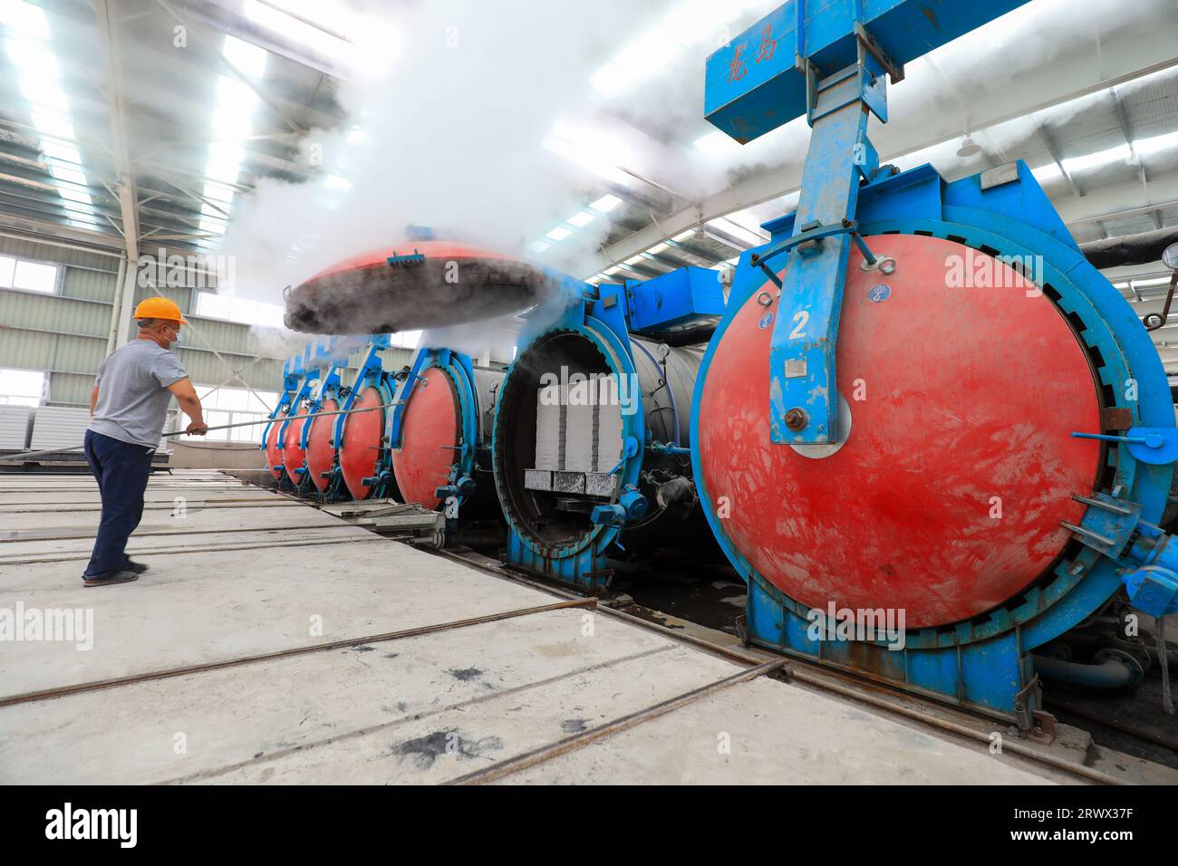 Contea di Luannan, Cina - 27 giugno 2023: I lavoratori stanno aprendo l'autoclave sulla linea di produzione di pannelli divisori leggeri in fabbrica Foto Stock