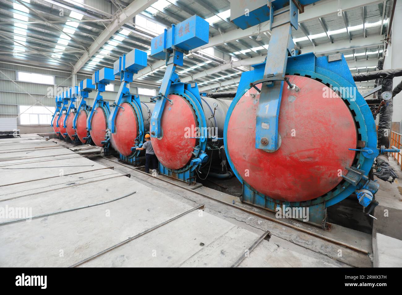 Contea di Luannan, Cina - 27 giugno 2023: I lavoratori stanno aprendo l'autoclave sulla linea di produzione di pannelli divisori leggeri in fabbrica Foto Stock