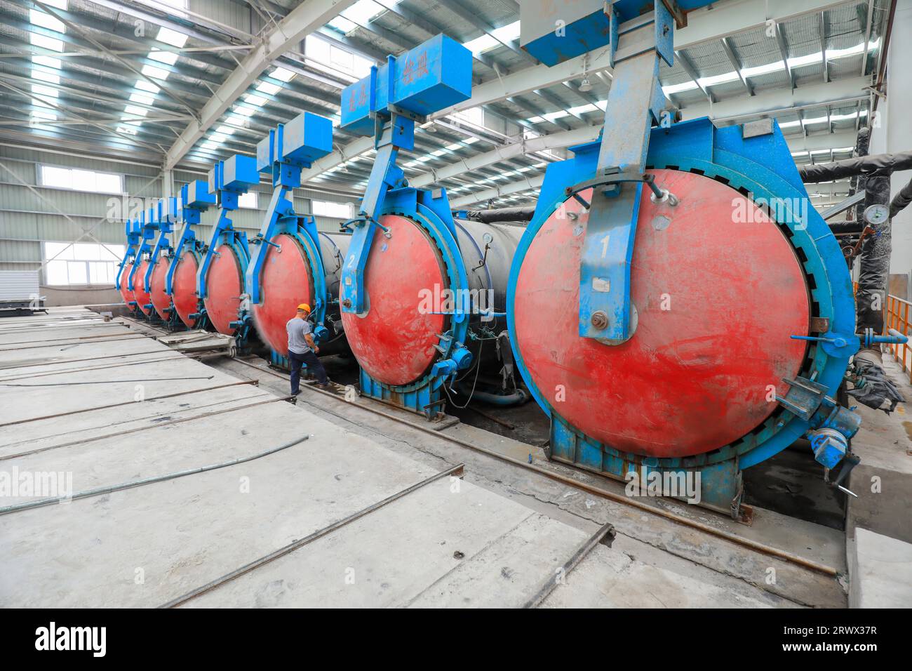 Contea di Luannan, Cina - 27 giugno 2023: I lavoratori stanno aprendo l'autoclave sulla linea di produzione di pannelli divisori leggeri in fabbrica Foto Stock