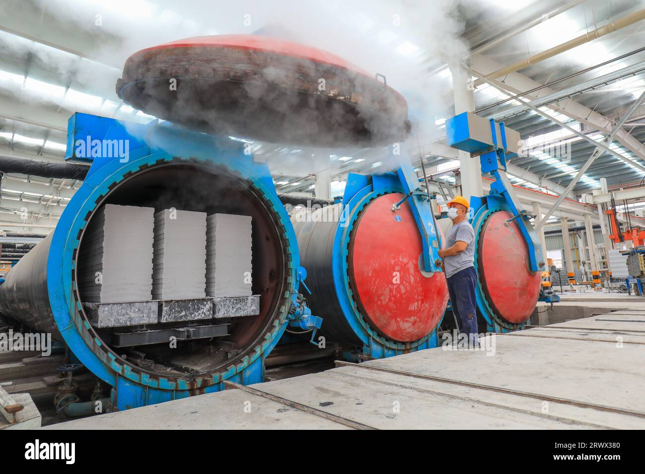 Contea di Luannan, Cina - 27 giugno 2023: I lavoratori stanno aprendo l'autoclave sulla linea di produzione di pannelli divisori leggeri in fabbrica Foto Stock