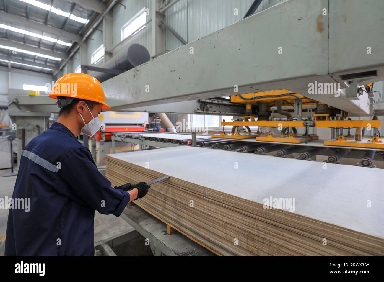 Contea di Luannan, Cina - 27 giugno 2023: I lavoratori stanno lavorando nervosamente sulla linea di produzione di pannelli divisori leggeri in fabbrica Foto Stock