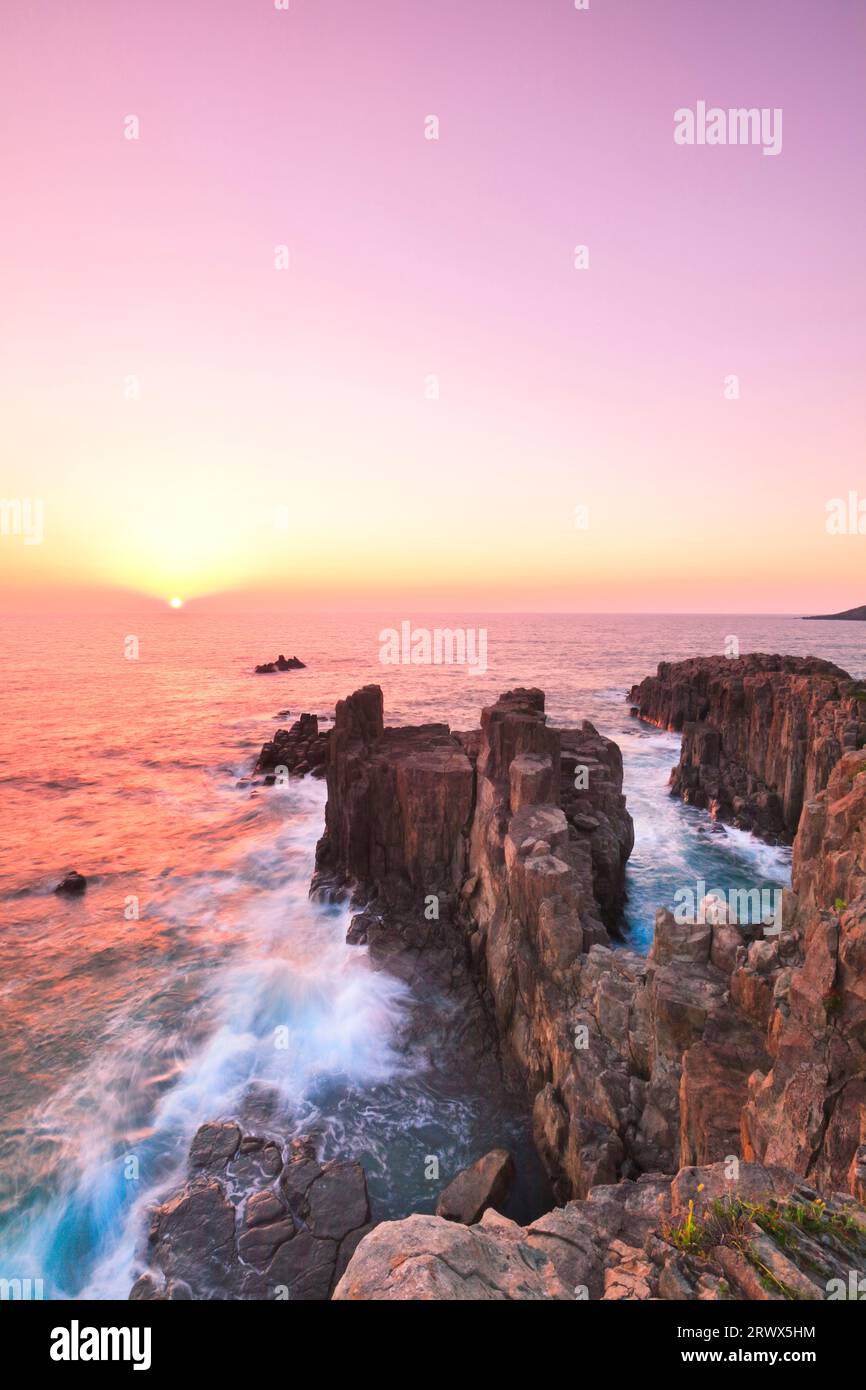 Tojinbo con le onde e il sole che tramonta Foto Stock