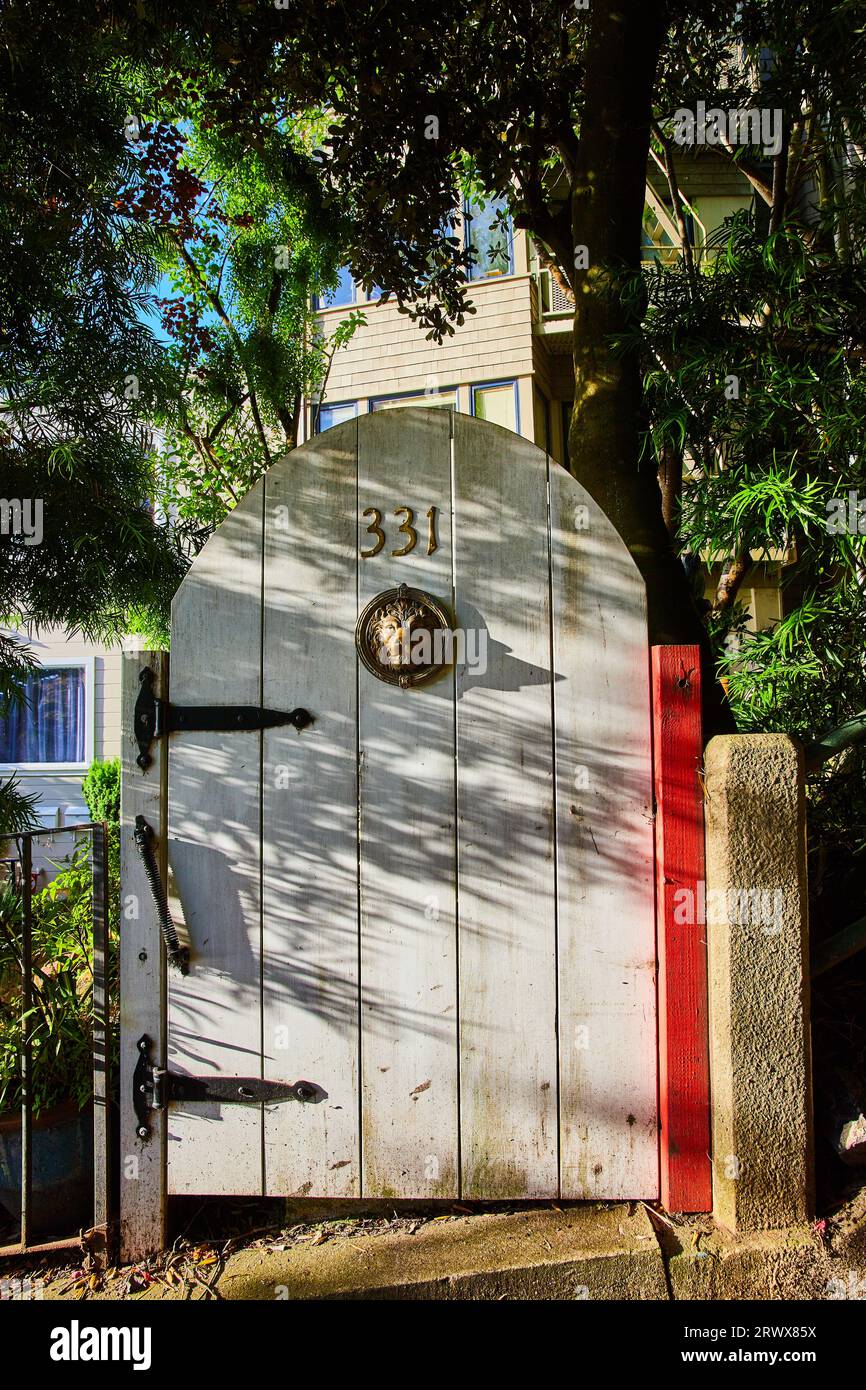 Porta curva bianca con cerniere nere e ingresso con testa di leone sull'ingresso della porta 331 Foto Stock