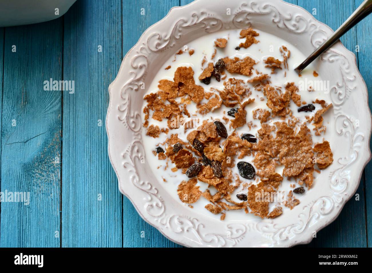 Ciotola di Raisin Bran su sfondo di legno blu Foto Stock