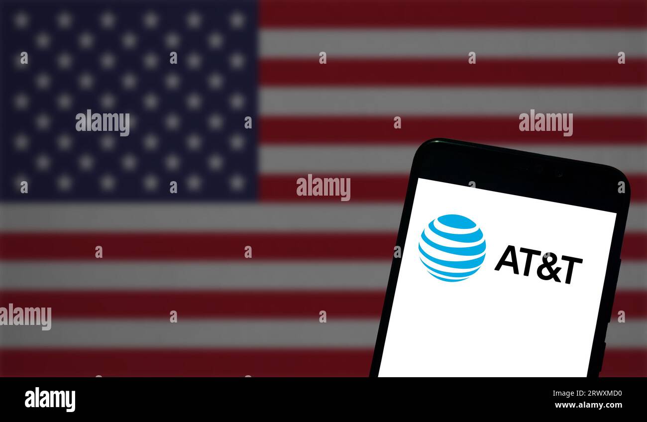 Buenos Aires, Argentina; 08-03-2023: Il logo AT&T è mostrato sullo schermo di un telefono cellulare e la bandiera degli Stati Uniti è fuori fuoco nello sfondo Foto Stock