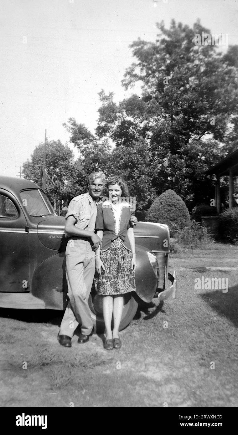 Una coppia non identificata in piedi accanto a un'auto. Fotografia rara: Da una collezione compilata da un militare britannico sconosciuto che copre la No. 1 Composite Demonstration, AA Battery, tour degli Stati Uniti, dall'11 luglio 1943. Si tratta di una delle oltre cento immagini della collezione che erano in media di circa 4 x 3 pollici. Foto Stock
