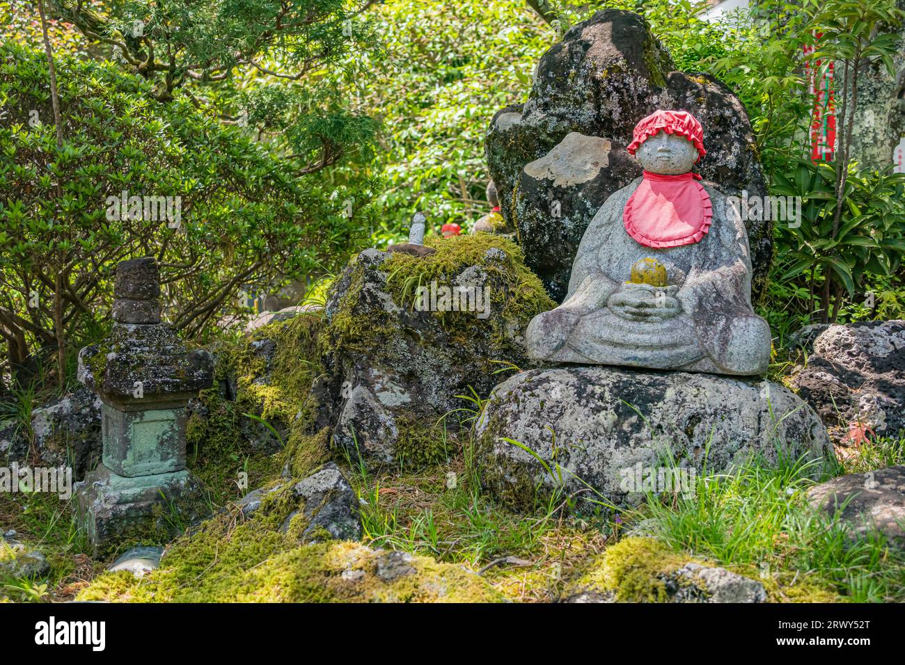 Statue Jizo uniche sparse in tutto il parco del tempio di Izu Shuzenji Foto Stock