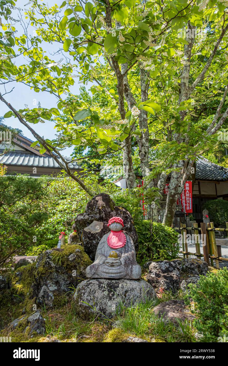 Statue Jizo uniche sparse in tutto il parco del tempio di Izu Shuzenji Foto Stock