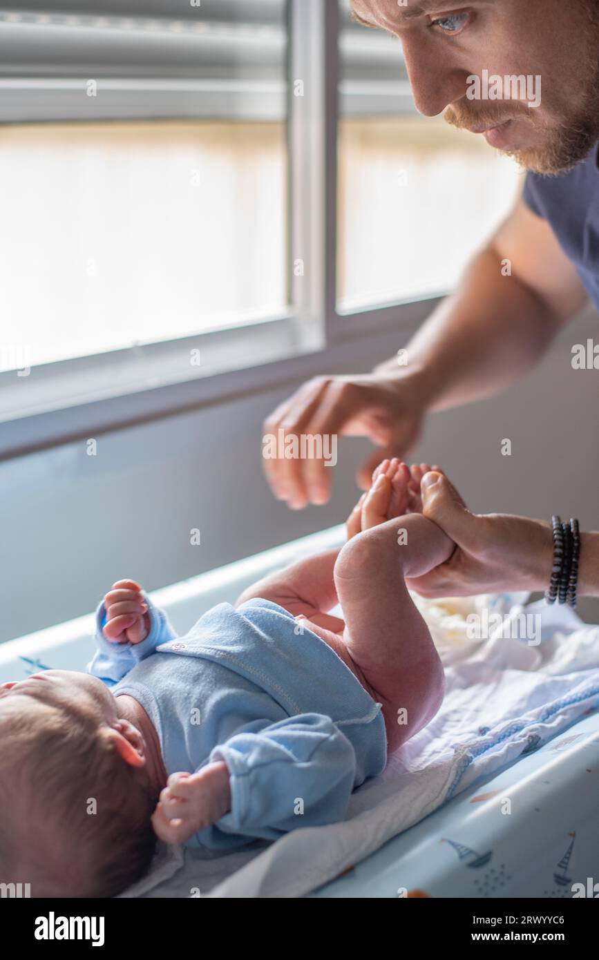 Padre che cambia pannolino in suo figlio appena nato Foto Stock