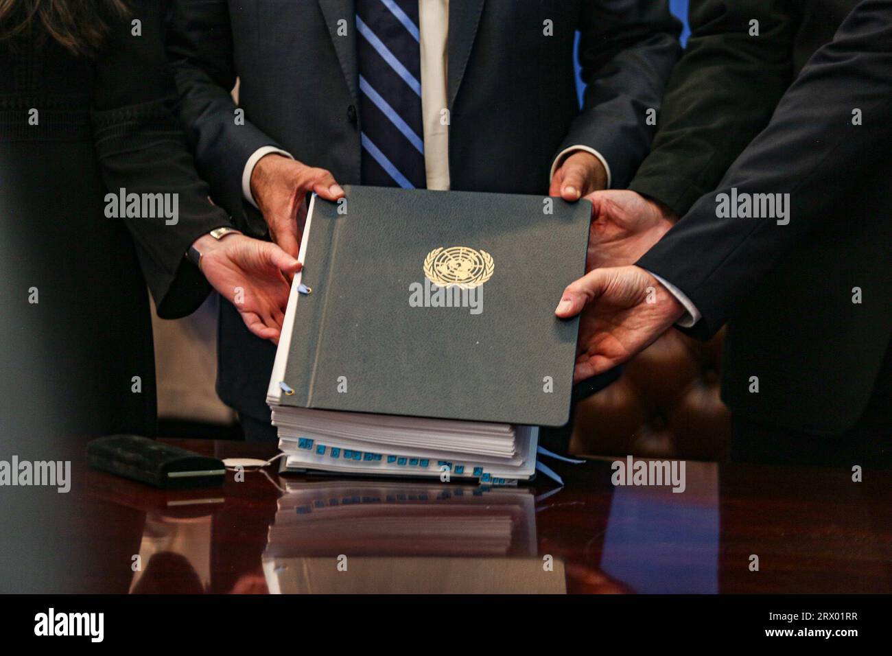New York, New York, USA. 20 settembre 2023. Le mani insieme tengono il libro del trattato di accordo ai sensi della Convenzione delle Nazioni Unite sul diritto del mare sulla conservazione e l'uso sostenibile della diversità biologica marina delle aree al di fuori della giurisdizione nazionale. (Immagine di credito: © Bianca Otero/ZUMA Press Wire) SOLO USO EDITORIALE! Non per USO commerciale! Foto Stock
