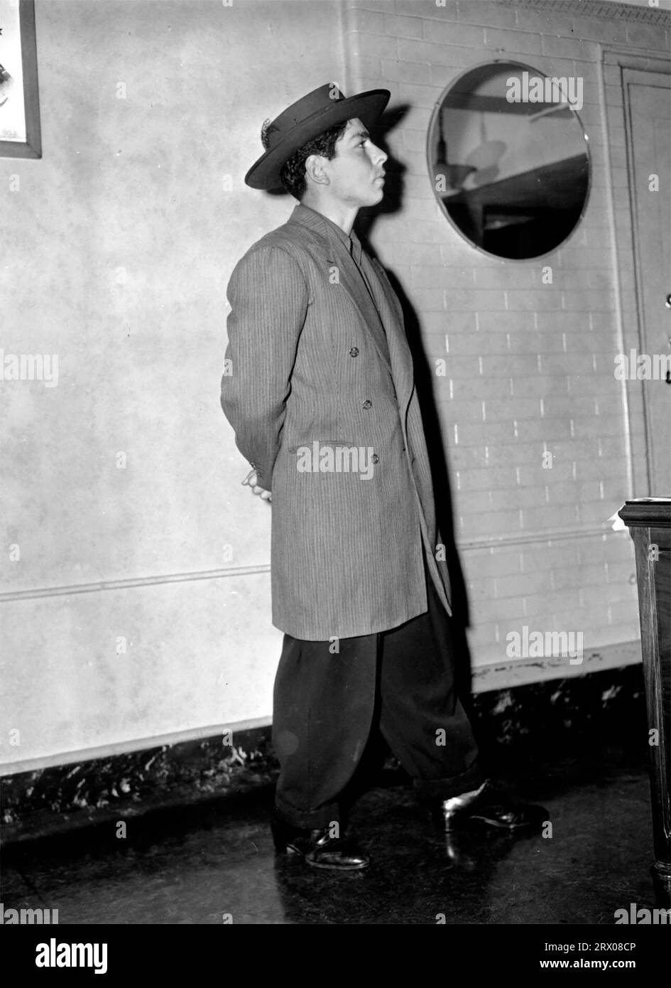 Frank Tellez, un ventiduenne messicano americano, modella una tuta da zoot mentre è arrestato durante le rivolte contro lo Zoot Suit (1943) Foto Stock